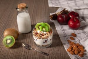 Здоровый завтрак мюсли с фруктами и йогуртом в стакане