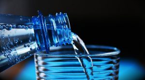 минеральная вода наливается из бутылки в стакан