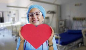 медсестра держит в руках картинку красного сердца