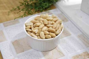 очищенный арахис в белой креманке на кухонном столе