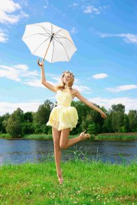 девушка в коротком желтом платье с зонтиком на фоне реки