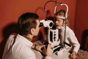 офтальмолог проверяет зрение у девочки на аппарате