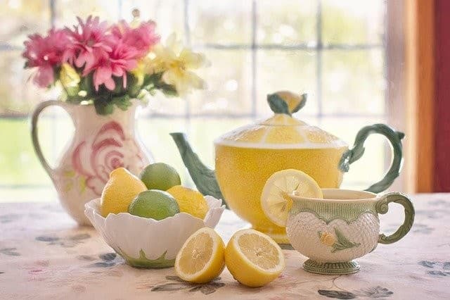 лимонный чай и лимоны подаются в красивом сервизе с изображением цитруса